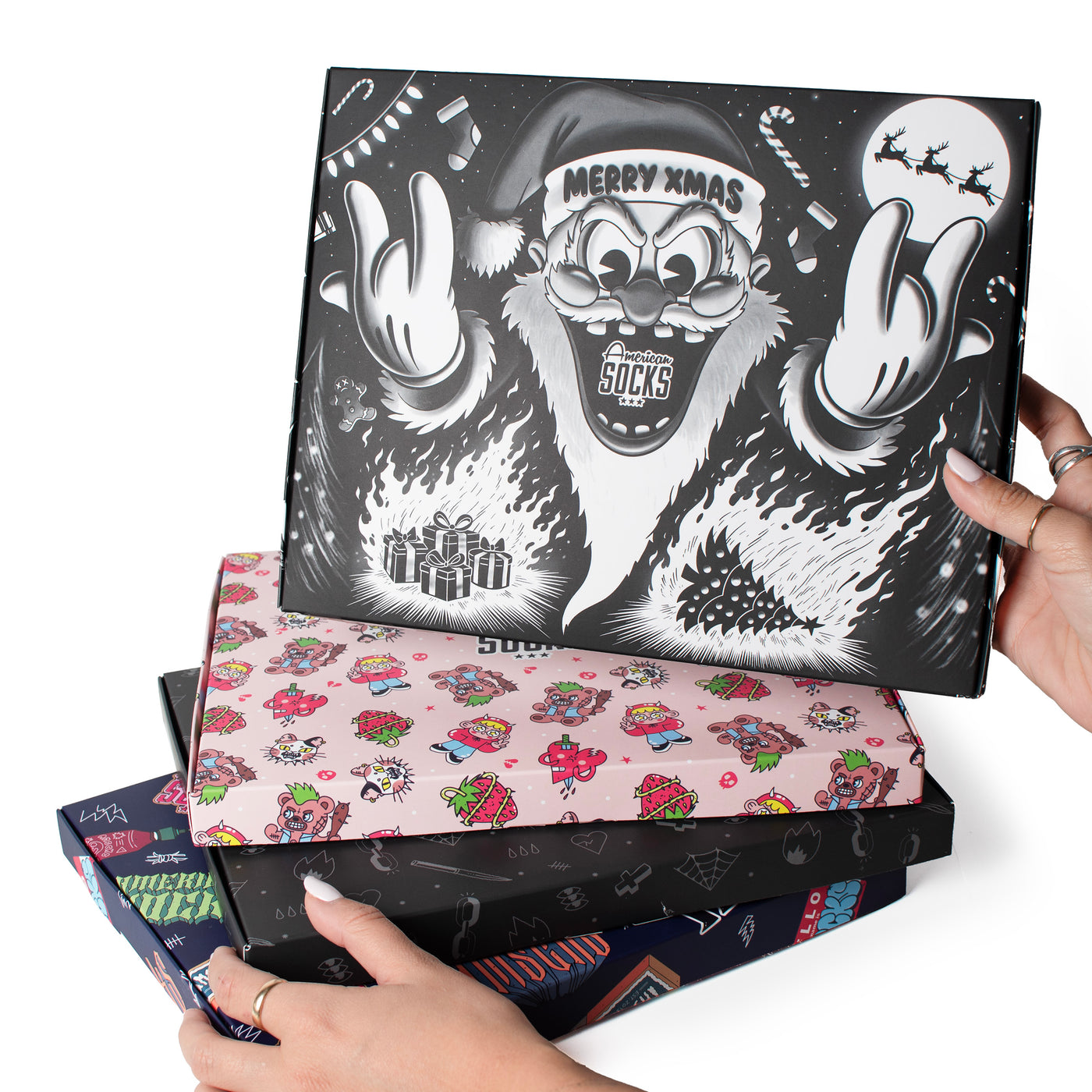 Piled up gift boxes with different designs held by hands by American Socks 